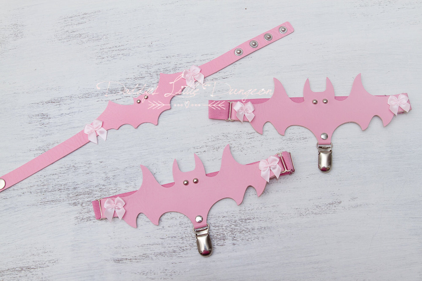 Cute pink DDLG collar and thigh garter set with bat and bows for bondage, BDSM and cosplay.