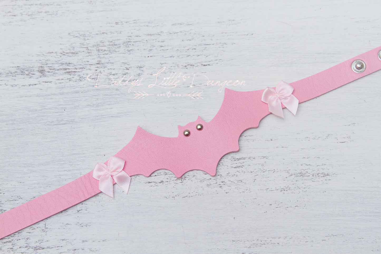 Cute pink DDLG collar and thigh garter set with bat and bows for bondage, BDSM and cosplay.